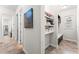 Hallway featuring tiled floors, a closet area with shelves, and a view leading to other rooms at 14880 Ellingsworth Ln, Winter Garden, FL 34787