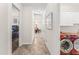 Bright hallway with neutral tones, tile flooring, and access to bedrooms, laundry room, and dining area at 14880 Ellingsworth Ln, Winter Garden, FL 34787