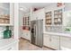 Bright kitchen features white cabinets, stainless steel refrigerator, and a mosaic backsplash at 14880 Ellingsworth Ln, Winter Garden, FL 34787
