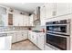 Gourmet kitchen showcases stainless steel appliances, white cabinets, mosaic backsplash, and recessed lighting at 14880 Ellingsworth Ln, Winter Garden, FL 34787