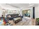 Open-concept living room and kitchen with a sectional sofa, modern rug, and sliding glass doors to the pool area at 14880 Ellingsworth Ln, Winter Garden, FL 34787