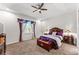 Cozy main bedroom featuring tray ceilings, ceiling fan, plush carpeting, and matching nightstands with Tiffany lamps at 14880 Ellingsworth Ln, Winter Garden, FL 34787