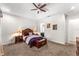 Relaxing main bedroom with tray ceiling, ceiling fan, en-suite bath, and rich, dark-wood furniture at 14880 Ellingsworth Ln, Winter Garden, FL 34787