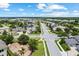 An aerial view showcases a Gathering-friendly neighborhood with lush trees, a playground, and well-maintained streets at 14880 Ellingsworth Ln, Winter Garden, FL 34787