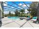 Screened-in pool area with a spa, lounge chairs, and lush tropical landscaping for privacy at 14880 Ellingsworth Ln, Winter Garden, FL 34787