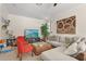 Well-lit living room with orange accent chairs, sectional sofa, and mounted television at 16108 Bristol Lake Cir, Orlando, FL 32828