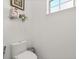 Simple and clean half-bath features a modern toilet, small window and neutral wall color at 16108 Bristol Lake Cir, Orlando, FL 32828