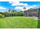Expansive green backyard featuring a screened-in pool area, swing set and mature landscaping at 1657 Tennyson Ct, Lake Mary, FL 32746