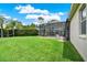 Lush green backyard featuring a screened-in pool area and mature landscaping at 1657 Tennyson Ct, Lake Mary, FL 32746