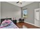 Bedroom features a comfortable bed, wood floors and a window at 1657 Tennyson Ct, Lake Mary, FL 32746