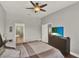 Bedroom boasts wood floors, ceiling fan and television, with an ensuite bathroom entrance visible at 1657 Tennyson Ct, Lake Mary, FL 32746