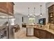 Kitchen with stainless appliances, granite counters, tile floor, and seamless flow to living area at 1657 Tennyson Ct, Lake Mary, FL 32746