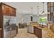 Open-concept kitchen with stainless fridge, granite counters, tile floor, and seamless flow to living areas at 1657 Tennyson Ct, Lake Mary, FL 32746