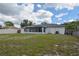 The home's backyard with lush greenery, a privacy fence, and a screened-in patio area at 1668 Fort Smith Blvd, Deltona, FL 32725