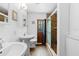 Bathroom with double sinks, hardwood floors, a wood door, and a glass-enclosed shower at 1805 Paloma Ave, Sanford, FL 32771