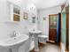 Bathroom with double sinks, hardwood floors, a wood door, and a glass-enclosed shower at 1805 Paloma Ave, Sanford, FL 32771