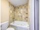A bathroom features a white tub with tiled walls and shelves at 1979 Staunton Ave, Winter Park, FL 32789