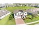 Aerial view of a beautiful home with solar panels, brick driveway, and spacious green lawn in a Gathering-friendly neighborhood at 2060 Panoramic Cir, Apopka, FL 32703