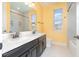 Bright bathroom featuring dual sinks, granite counters, and tub shower combo at 2060 Panoramic Cir, Apopka, FL 32703