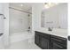 Modern bathroom features dark cabinets, tub with light gray tile, and quartz counters at 2060 Panoramic Cir, Apopka, FL 32703
