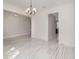 Open-concept dining area with modern light fixture and view into connecting rooms, featuring stylish tile flooring at 2060 Panoramic Cir, Apopka, FL 32703