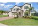 Charming two-story home boasts a stone entryway, three-car garage, and meticulously maintained lawn at 2060 Panoramic Cir, Apopka, FL 32703
