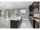Elegant kitchen with an island, pendant lights, stainless steel appliances, and access to the backyard at 2060 Panoramic Cir, Apopka, FL 32703