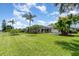 Spacious backyard with lush green grass, tropical plants, and a screened-in lanai at 2135 Springwater Ln, Port Orange, FL 32128