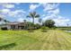 Expansive green backyard with a scenic pond view and tropical trees at 2135 Springwater Ln, Port Orange, FL 32128