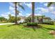 Beautifully landscaped front yard featuring vibrant green lawn, mature trees, and manicured shrubbery at 2135 Springwater Ln, Port Orange, FL 32128