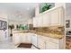 Bright kitchen with granite countertops, white cabinets and stainless steel appliances overlooking the backyard at 2135 Springwater Ln, Port Orange, FL 32128
