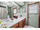 Bright bathroom with double sinks, white countertops, and wood cabinets at 2209 Fairglenn Way, Winter Park, FL 32792