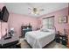 Bright bedroom with light pink walls, black lacquer furnishings, and ceiling fan at 2209 Fairglenn Way, Winter Park, FL 32792
