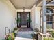 Inviting front entrance with a decorative door, potted plants, brick accents, and stylish house numbers at 2209 Fairglenn Way, Winter Park, FL 32792