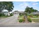 Charming single-story home with a well-manicured lawn, mature trees, and a two-car garage on a sunny day at 2209 Fairglenn Way, Winter Park, FL 32792