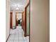 Neutral hallway showcasing clean tile floors and multiple wooden doorframes at 2209 Fairglenn Way, Winter Park, FL 32792