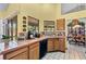 Functional kitchen sink area with tile countertops, wooden cabinets, and a view to the outdoor patio at 2209 Fairglenn Way, Winter Park, FL 32792