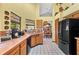 Well-lit kitchen with ample counter space, wooden cabinets, black appliances, and a view into the dining area at 2209 Fairglenn Way, Winter Park, FL 32792