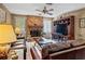 Cozy living room with leather sofas, a brick fireplace, and a ceiling fan at 2209 Fairglenn Way, Winter Park, FL 32792
