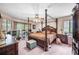 This bedroom features a four-poster bed, a ceiling fan, and access to the backyard at 2209 Fairglenn Way, Winter Park, FL 32792