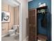 Stylish half-bath with a wooden shelf on a blue wall and unique art at 2241 Southbury Dr, Kissimmee, FL 34744