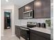 Modern kitchen with stainless steel appliances, white subway tile backsplash, and dark wood cabinetry at 2241 Southbury Dr, Kissimmee, FL 34744
