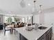 Open-concept kitchen with island, modern lighting, and a seamless flow to the dining and living areas at 2241 Southbury Dr, Kissimmee, FL 34744