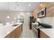 Spacious kitchen featuring wood cabinetry, stainless steel appliances, and a center island at 235 Aidans Lndg, Haines City, FL 33844