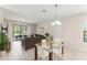 Open floor plan showcasing a living room and dining area with tile floors and outdoor views at 235 Aidans Lndg, Haines City, FL 33844
