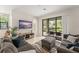 Comfortable living room with a large sectional sofa, patterned rug, and access to the patio at 235 Aidans Lndg, Haines City, FL 33844