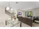 Open-concept living space with a glass table, staircase, and sliding doors to the outdoor patio at 235 Aidans Lndg, Haines City, FL 33844