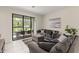 Cozy living room with a sofa, ottoman, and sliding glass doors leading to an outdoor area at 235 Aidans Lndg, Haines City, FL 33844