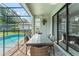 Relaxing patio area with seating overlooking screened pool and yard at 235 Aidans Lndg, Haines City, FL 33844