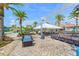 Paver patio area with outdoor seating, stage, and nearby community pool and playground at 235 Aidans Lndg, Haines City, FL 33844